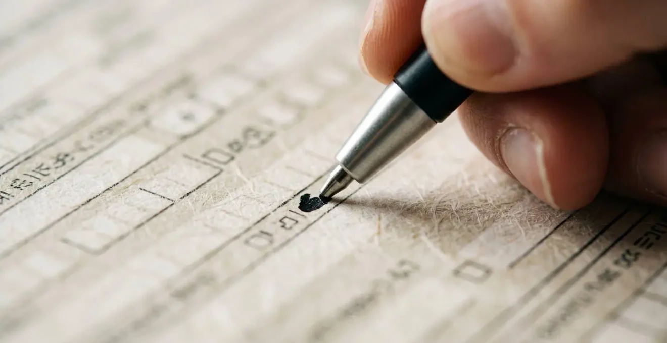 Gros plan sur des mains complétant un formulaire administratif d'assurance avec un stylo