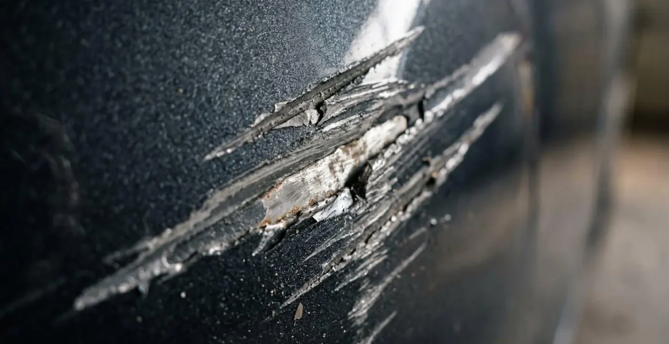 Gros plan sur une carrosserie endommagée avec traces de rayures profondes